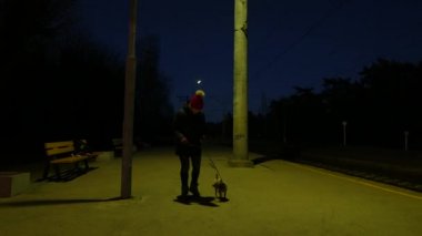 Geceleri tren istasyonunda bir köpek olan kadın.
