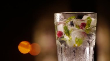 İçki, buz, nane ve bulanık bir arka plan üzerinde meyveleri ile cam