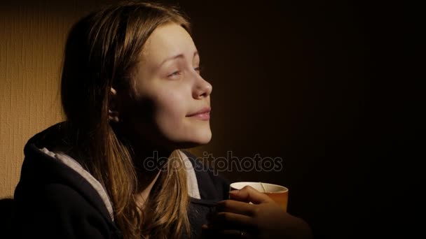 Carino giovane adolescente ragazza sta bevendo caffè o tè a casa . — Video Stock