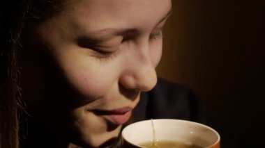 Sevimli genç genç kız evde kahve veya çay içiyor. Portre