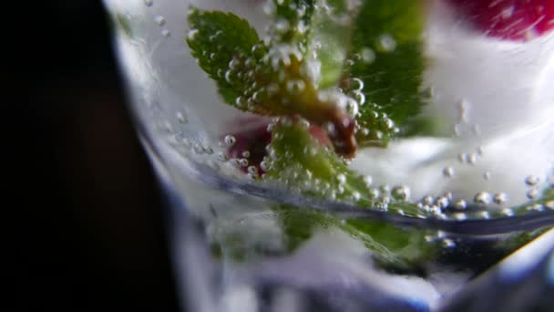 Glas med dricka, is, mint och bär. Närbild — Stockvideo