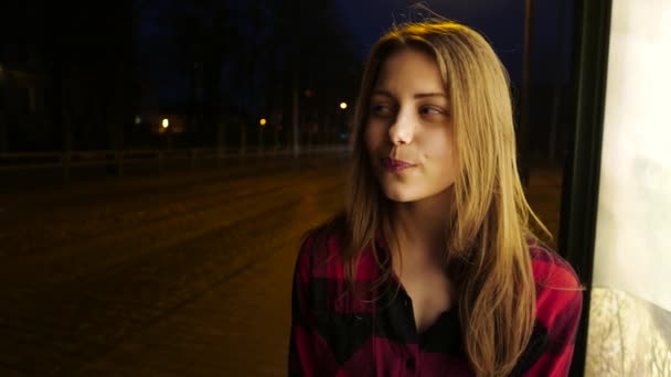 Porträt eines niedlichen, nachdenklich lächelnden Teenie-Mädchens auf einer nächtlichen Straße in der Stadt. — Stockvideo