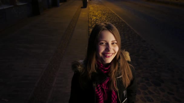 一个可爱的微笑青少年女孩，夜间城市街道上的肖像。笑和开心 — 图库视频影像