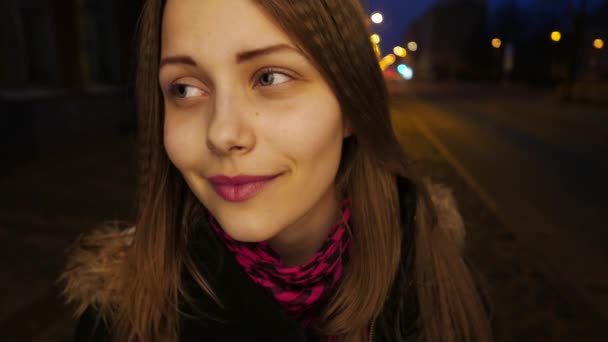 Портрет милой задумчивой улыбающейся девочки-подростка на улице ночного города . — стоковое видео