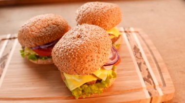 Üç taze iştah açıcı hamburger bir salata ve domates ile