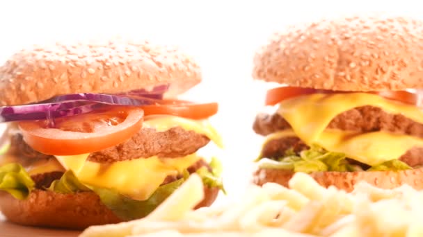 Гамбургер з цибулею, помідорами та салатом на яскравому фоні — стокове відео