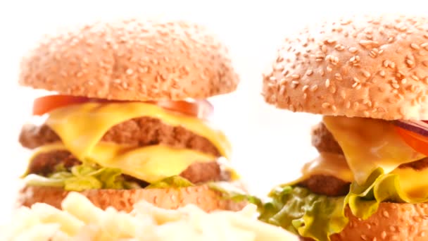 Una hamburguesa con cebolla, tomate y ensalada sobre un fondo brillante — Vídeos de Stock