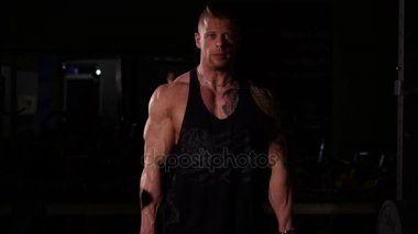 Bir spor salonunda genç vücut geliştirmeci deadlifting. 60-24fps Uhd