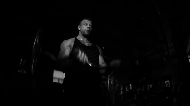 Νέοι bodybuilder κατάρτισης σε ένα γυμναστήριο. Δραματικές σκηνές μαύρο και άσπρο. — Αρχείο Βίντεο