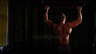 Bir spor salonunda eğitim genç vücut geliştiricisi. Pullups yapıyor. 60-24fps 4k
