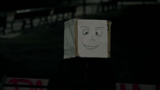 Chica de noche vistiendo una caja con una sonrisa en la cabeza. Concepto de diversión y positividad. 4K UHD 60 a 24fps — Vídeo de stock