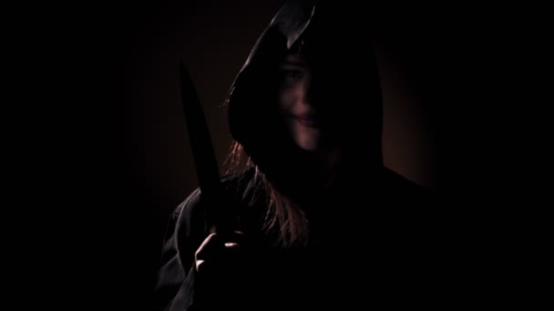 Grim girl in a ritual wardrobe with a knife in a dark — Stock Video