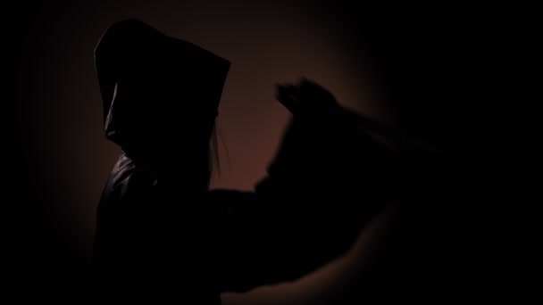 Grim girl dans une garde-robe rituelle avec un couteau dans un noir 