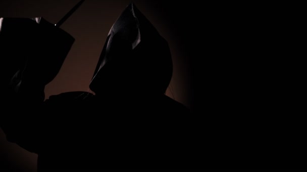 Мрачная девушка в ритуальном шкафу с ножом в темноте — стоковое видео