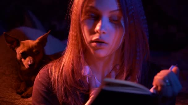 Teen κορίτσι ανάγνωση τρομακτικό βιβλίο τη νύχτα — Αρχείο Βίντεο