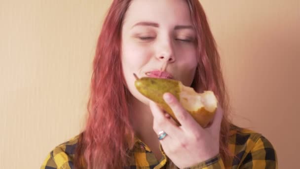 Милая девочка-подросток ест грушу — стоковое видео