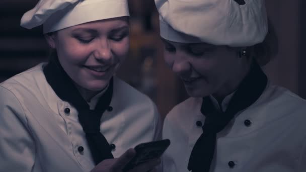 Dos mujeres cocineras se divierten en una cocina — Vídeo de stock