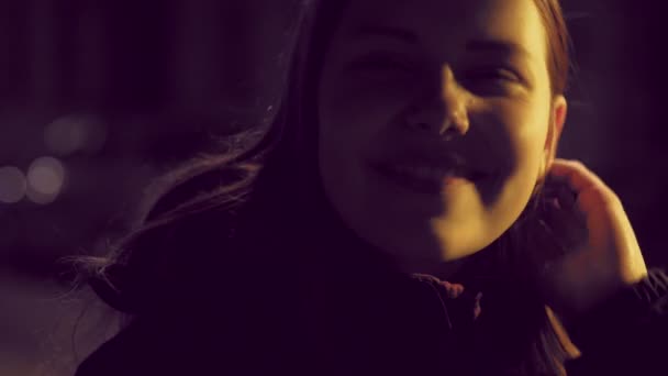 Retrato de una linda chica adolescente sonriente pensativa en una calle nocturna de la ciudad. lentitud UHD 4K — Vídeos de Stock