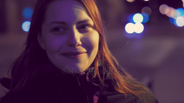 Retrato de una linda chica adolescente sonriente pensativa en una calle nocturna de la ciudad. lentitud UHD 4K — Vídeo de stock