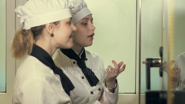 Две кухарки веселятся на кухне. — стоковое видео