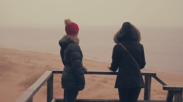 Dos chicas disfrutan de la lluvia en un bosque de primavera cerca del mar. 60 a 24fps 4K UHD — Vídeos de Stock