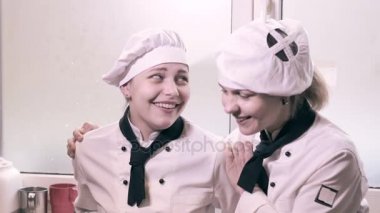 İki kadın eğlenceli bir mutfakta yemek