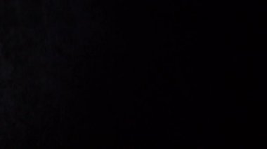 Biraz toz koyu arka plan üzerine akan sıvı parçacıkların