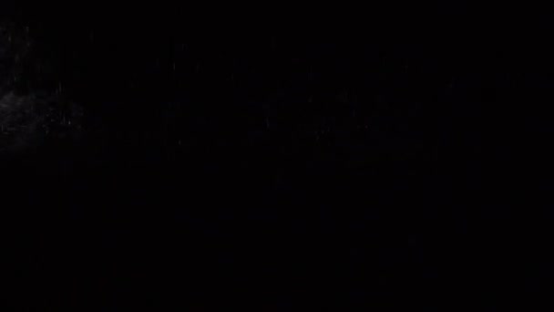 Etwas Staub flüssiger Teilchen fließt auf dunklem Hintergrund — Stockvideo