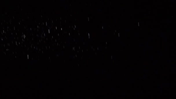 Некоторая пыль жидких частиц течет на темном фоне — стоковое видео