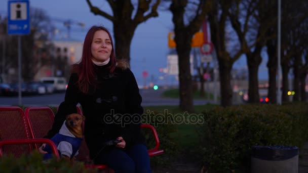 Menina adolescente com um cachorrinho em uma rua noturna — Vídeo de Stock