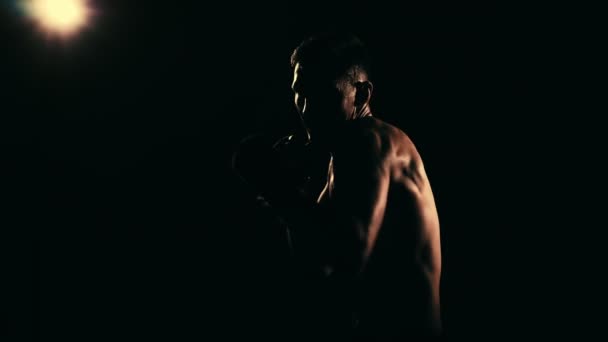 Entrenamiento de boxeadores en un gimnasio, iluminación dramática. Movimiento lento — Vídeo de stock