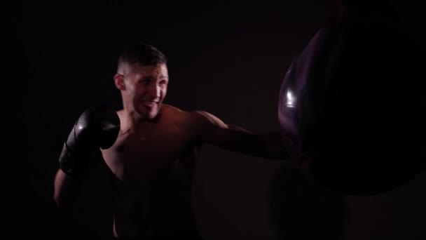 Boxer opleiding in een sportschool, dramatische verlichting. Slow motion — Stockvideo