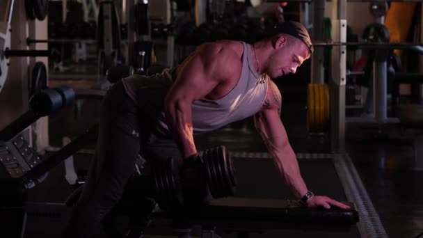 Entrenamiento de culturistas jóvenes en un gimnasio. cámara lenta 4K — Vídeo de stock