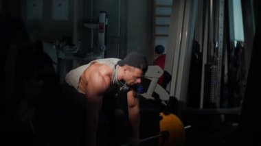 Bir spor salonunda eğitim genç vücut geliştiricisi. Yavaş hareket 4k