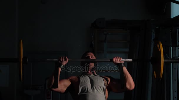 Junger Bodybuilder beim Training in einem Fitnessstudio. Zeitlupe 4k — Stockvideo