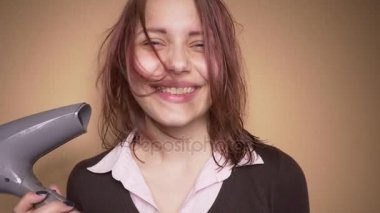 Duygusal mutlu genç kız komik yüzler saç kurutma sırasında olun. Ağır çekim