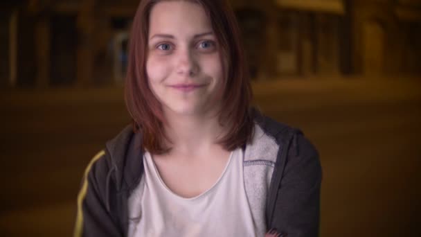 Porträtt av en söt leende tonåring flicka på en natt stadsgata. 4 k slowmo — Stockvideo