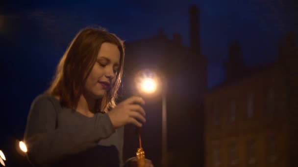 Portret van een schattige lachende tiener meisje op een nacht straat zeepbellen blazen — Stockvideo