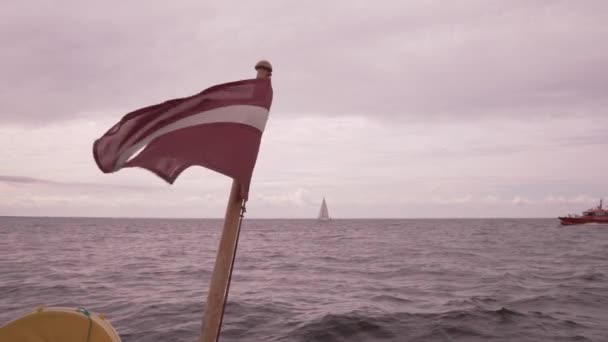 Lett zászló. Egy hajó 4k slowmo a tenger hullámai — Stock videók
