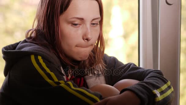 Chica deprimida en casa. Chica triste cerca de la ventana . — Vídeo de stock