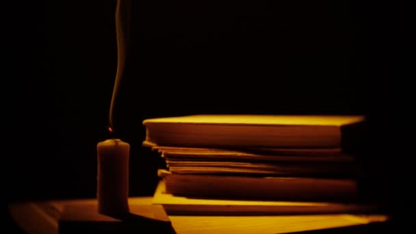 Libros y velas. Fuego y humo. Biblioteca en la oscuridad . — Vídeo de stock