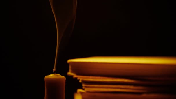 Boeken en kaars. Vuur en rook. Bibliotheek in duisternis. — Stockvideo