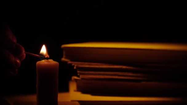 Boeken en kaars. Vuur en rook. Bibliotheek in duisternis. — Stockvideo