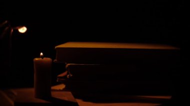 Kitap ve mum. Ateş ve duman. Işık ve darbe mum dışarı. Ağır çekim.