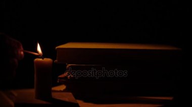 Kitap ve mum. Ateş ve duman. Işık ve darbe mum dışarı. Ağır çekim.