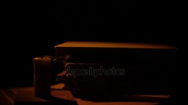 Kitap ve mum. Ateş ve duman. Işık ve darbe mum dışarı. Ağır çekim.