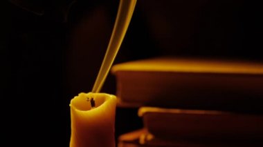 Kitap ve mum. Ateş ve duman. Işık ve darbe mum dışarı. Ağır çekim.