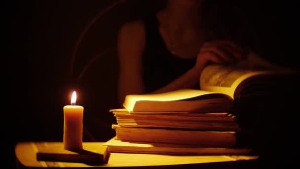 書籍やキャンドル。火と煙。女性が本を読んでいます。. — ストック動画
