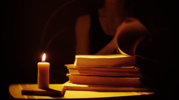 Livros e velas. Fogo e fumo. As mulheres estão lendo os livros . — Vídeo de Stock