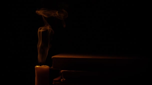 Libri e candele. Fuoco e fumo. Accendi e spegni la candela. Rallentatore . — Video Stock